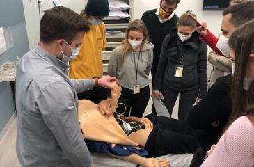 students looking at medical manikin
