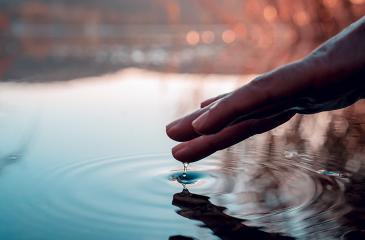 hand touching water for ripple concept