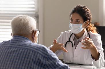female physician talking to older male patient