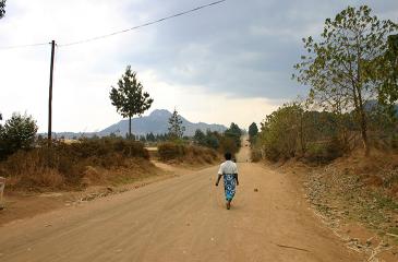 Woman walking down dusty road in central Malawi