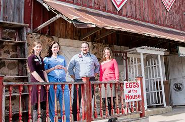Medical professionals standing in front of a barn