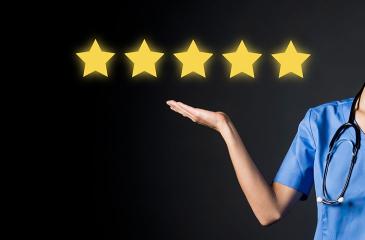 A doctor in a medical suit shows with her hand five stars