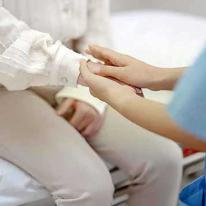 Nurse or doctor handing hands with patient