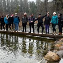 Students standing on log