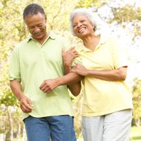 older adults linked arms walking and smiling