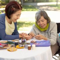 Older woman and younger woman make crafts together 