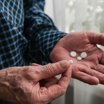 older adult with medication in hands