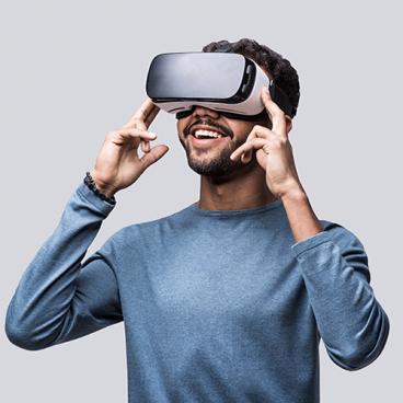 smiling person looking through a virtual reality headset